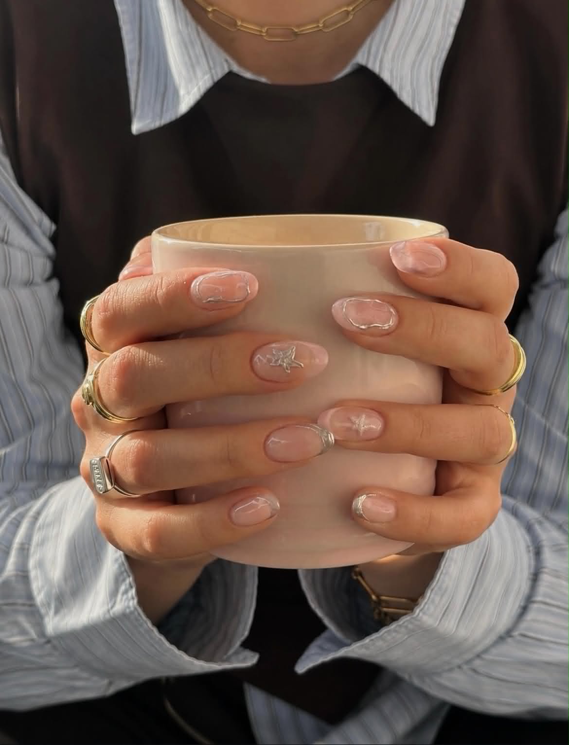 Verzorgde nagels met een kop koffie in het atelier